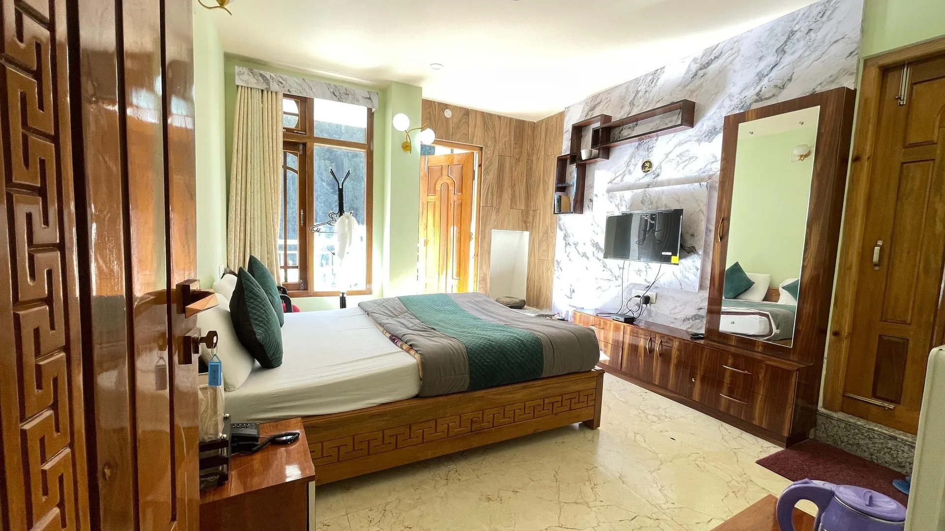 Deluxe Room with a queen bed, television and wooden interior