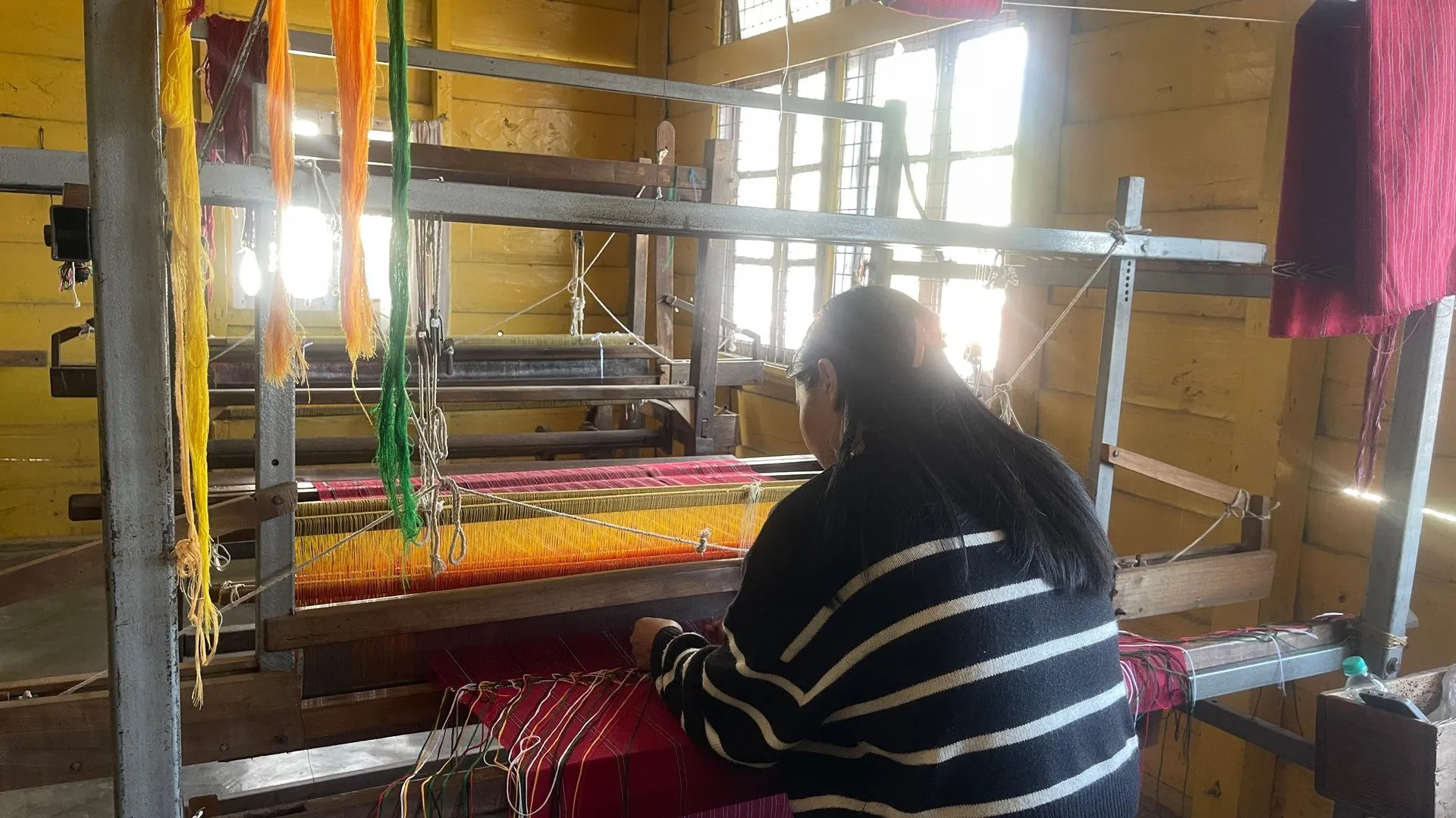 A local artisan weaving a colourful traditional textile in Tawang