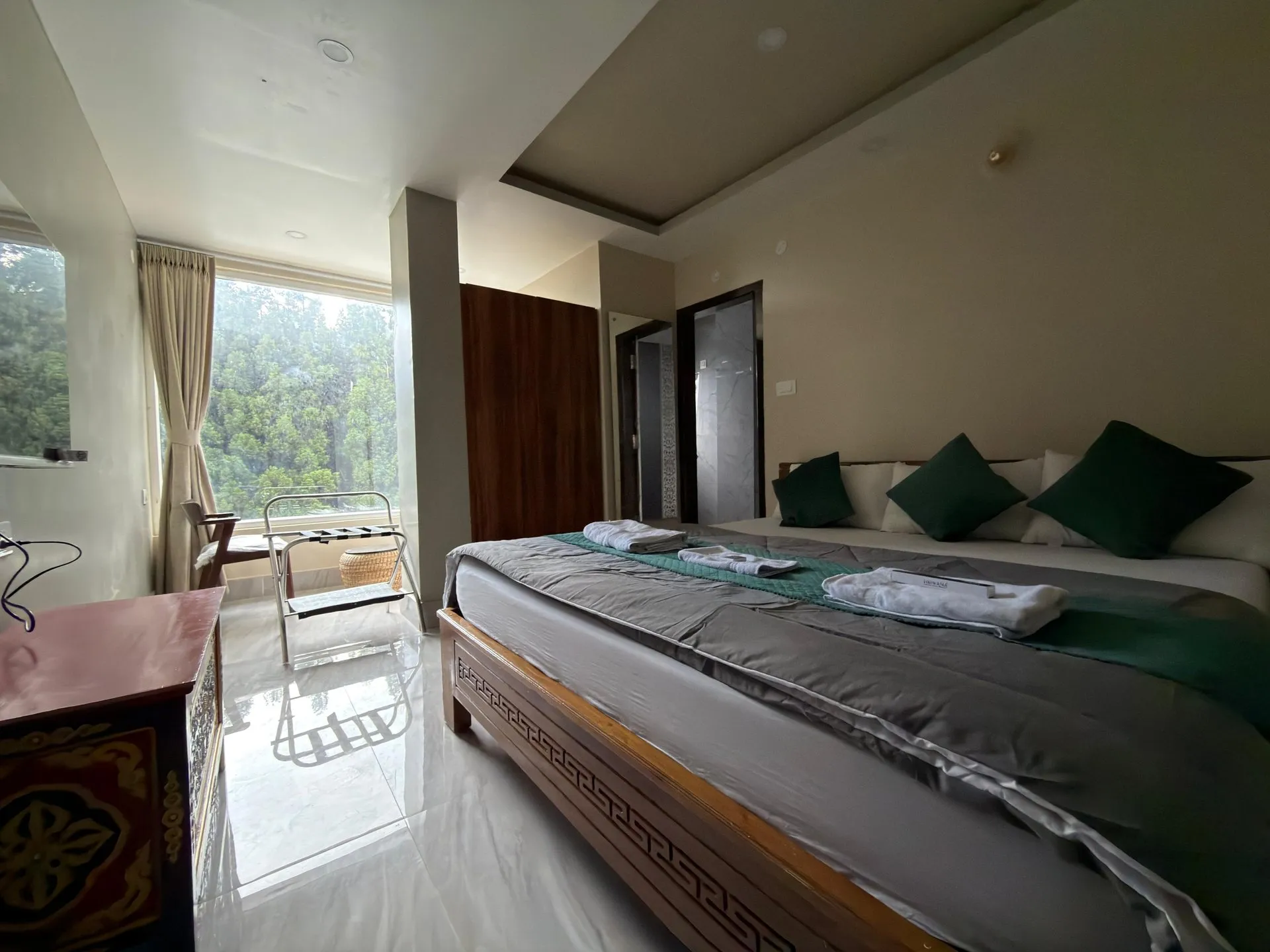 Super Deluxe Room interior with a made bed and window seating