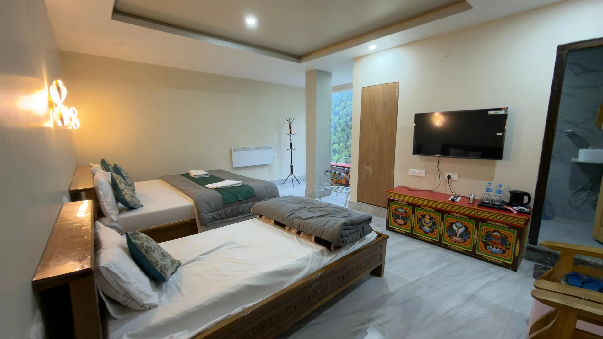 Triple Bedded Room at Rikya Retreat with multiple beds and a television